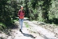 One lovely slim fit thin teen girl enjoying, listening to music in the forest while walking spring day forest or park Royalty Free Stock Photo