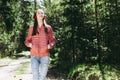 One lovely slim fit thin teen girl enjoying, listening to music in the forest while walking spring day forest or park Royalty Free Stock Photo