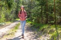 One lovely slim fit thin teen girl enjoying, listening to music in the forest while walking spring day forest or park Royalty Free Stock Photo