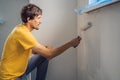 One male house painter worker painting and priming wall with painting roller. DIY Royalty Free Stock Photo