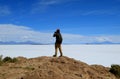 One male tourist taking photos of the imense Uyuni salt flats from Isla Incahuasi, the outcrop in the middle of the salt flats