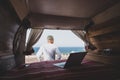 One man alone isolated from the society with his minivan camper traveling and enjoying vacations - digital nomad people lifestyle Royalty Free Stock Photo