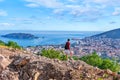 One man with a backpack looks at the roofs of the city of Budva