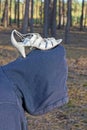 one man in a blue hood bowed his head under a womans white shoe with a heel Royalty Free Stock Photo