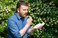 Pollen allergy in springtime concept. Man sneezing in a tissue Royalty Free Stock Photo