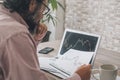 One man looking and studying stock market charts at the desk with opened laptop and connection. Concept of economy crypto forex