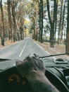 One man pov or his hands driving a vehicle on a long scenic trees asphalt road. Traveling and driving camper van truck. Freedom Royalty Free Stock Photo