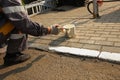 One man round brush paints white paint curbstone near the road. concept urban service Royalty Free Stock Photo