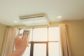 One man`s hand is pressing the air conditioner remote in his hand to rest Royalty Free Stock Photo