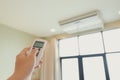 One man`s hand is pressing the air conditioner remote in his hand to rest Royalty Free Stock Photo