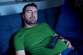 One guy sleeping on the sofa at night watching tv Royalty Free Stock Photo