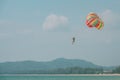 One man starting parasailing fly with colorful parachute. Close up photo on clear blue sky Royalty Free Stock Photo