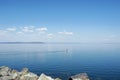 One man on a sup board alone rowing on a smooth smooth clear sea against a clear blue sky with clouds. Sea sports. Outdoor Royalty Free Stock Photo