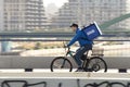 One man working for Wolt delivery service, riding a bike over the city bridge