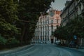 One of the many vintage houses in Krakow old town or close by, lit by setting sun. Visible road and tram tracks below