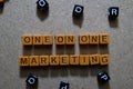 One on One Marketing on wooden cubes. On table background