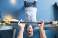 One mature man lying down on the bench of the gym training hus body to be fitness and active senior - man helping he holding de