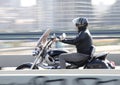 One mature man riding fast motorbike over the city street bridge