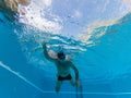 One mature man or senior training and doing exercise swimming in a pool alone - under water view of pensioner swimming  - active Royalty Free Stock Photo