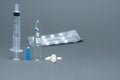 One medical ampoule, syringe and pills on a gray background. Medicines concept Royalty Free Stock Photo