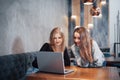 One-on-one meeting.Two young business women sitting at table in cafe.Girl shows colleague information on laptop screen Royalty Free Stock Photo