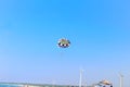 one men are flying in the blue sky using a colorful parachute,Happy man flying parasailing at kutch Gujarat india,mandvi kutch Royalty Free Stock Photo