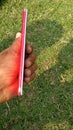 One men holding a oppo f5 mobile in her hend colour red