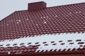 One metal chimney on a red tiled roof of a private house in white snow Royalty Free Stock Photo