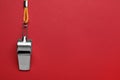 One metal whistle with cord on red background, top view. Space for text Royalty Free Stock Photo