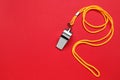 One metal whistle with cord on red background, top view. Space for text Royalty Free Stock Photo
