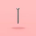 One Metallic Screw on Red Background
