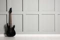 One modern electric guitar near grey wall. Space for text Royalty Free Stock Photo