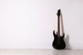 One modern electric guitar near white wall. Space for text Royalty Free Stock Photo