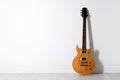 One modern electric guitar near white wall. Space for text Royalty Free Stock Photo