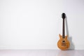 One modern electric guitar near white wall. Space for text Royalty Free Stock Photo