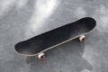 One modern skateboard with black griptape on ground outdoors Royalty Free Stock Photo