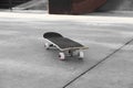 One modern skateboard with black griptape on ground outdoors Royalty Free Stock Photo