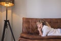 One modern woman lay down on the sofa at home surfing the web with laptop and wireless internet connection. Peope using computer Royalty Free Stock Photo