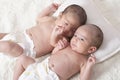 One month newborn twin babies with diaper resting on bed Royalty Free Stock Photo