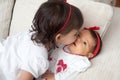 One month old baby girl being kissed by her big sister at home. Love between siblings concept. Family concept