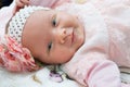 Beautiful newborn baby girl with a flower on her head smiling and looking at camera Royalty Free Stock Photo