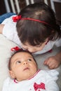 One month old baby girl at home with her big sister. Love between siblings concept. Family concept