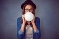 One more big breath. a fun-loving young woman blowing up a balloon in studio. Royalty Free Stock Photo