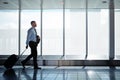 One more flight to go. a businessman walking down an airport corridor while on a business trip. Royalty Free Stock Photo