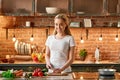 One of the most meditative times of my day is when I`m cooking. Happy young woman cutting fresh vegetables in modern Royalty Free Stock Photo