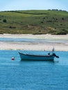 One motorboat is anchored near the picturesque shores of southern Ireland. Seaside landscape. Green hilly coast, boat on seashore Royalty Free Stock Photo