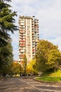 One multi-storey residential building with balconies in the city among green trees on light blue sky background Royalty Free Stock Photo