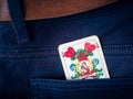 One old ace card from deck of playing cards with german suit - heart, in pocket of blue pants Royalty Free Stock Photo