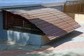 Old basement window under a brown metal roof on the sidewalk Royalty Free Stock Photo