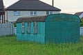 One old big metal trailer with windows stands in green grass
